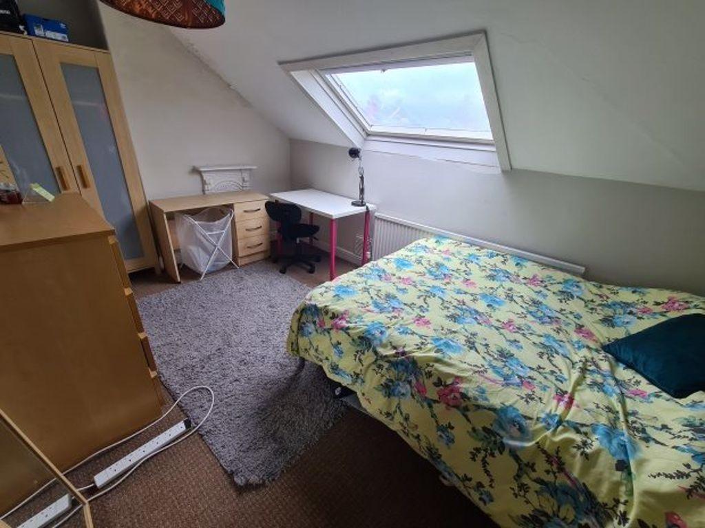 A cozy bedroom featuring a double bed with a co...