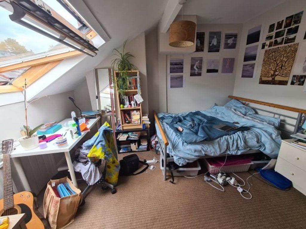 A cozy student bedroom featuring a single bed, ...