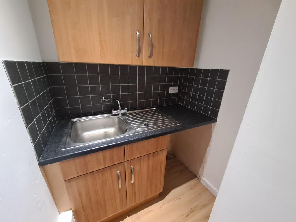 A compact kitchen area featuring a stainless st...