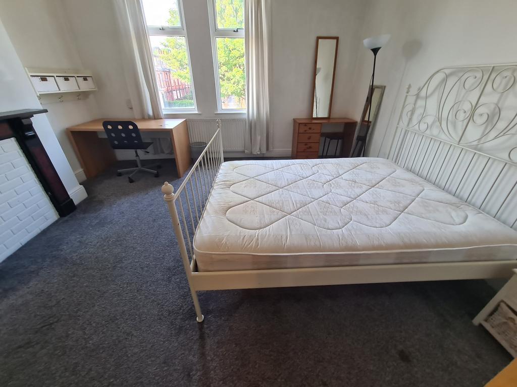 A bright, tidy bedroom featuring a comfortable ...