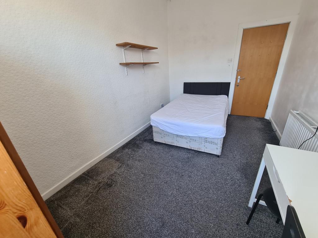 A simple, well-maintained bedroom featuring a s...