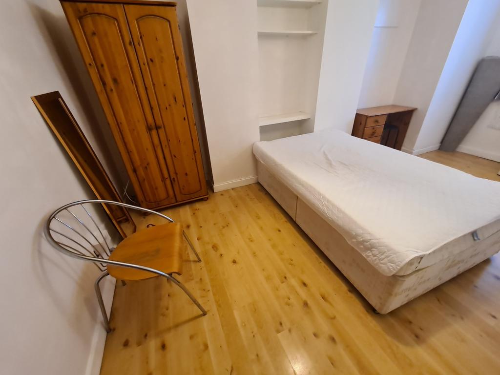 A cozy bedroom featuring a neatly made bed, woo...
