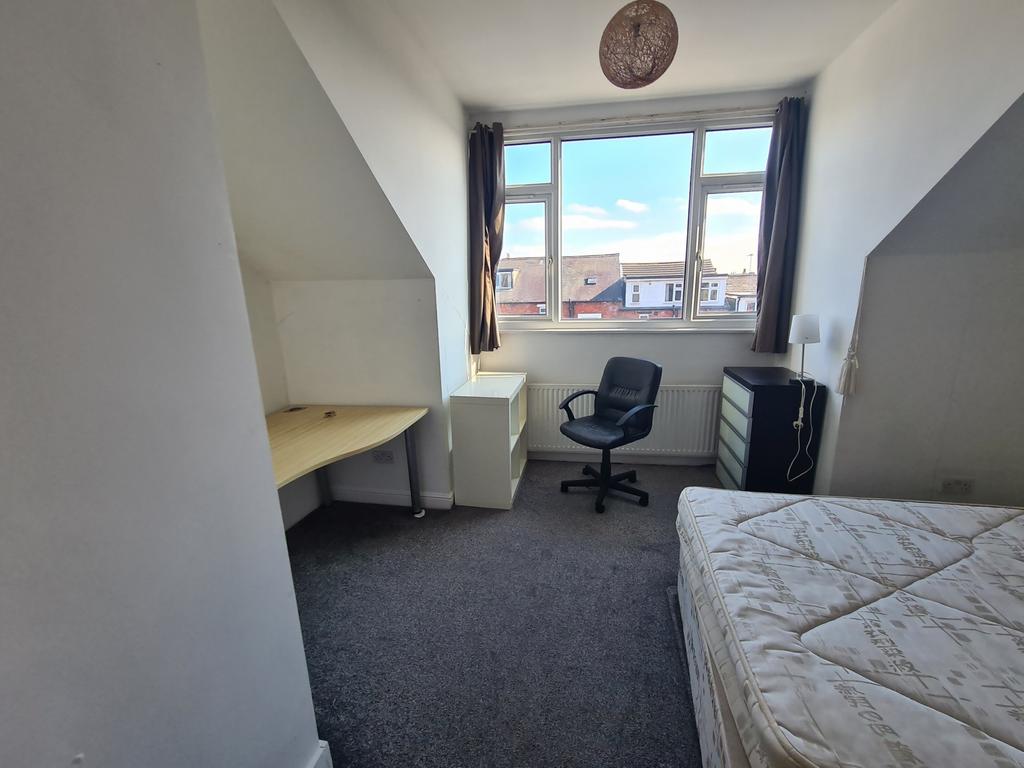 A cozy and well-maintained bedroom with a large...