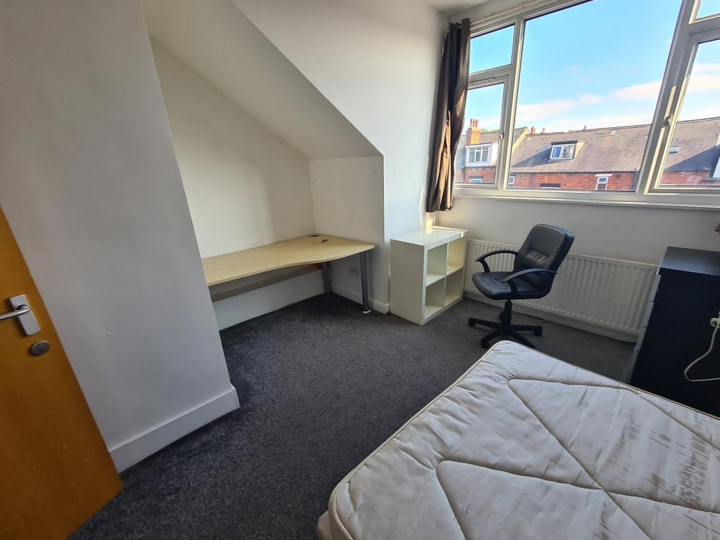 A bright and tidy bedroom featuring a comfortab...