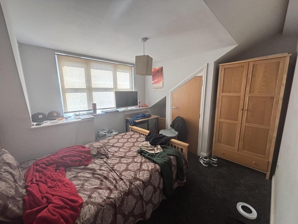 A cozy bedroom featuring a double bed with patt...