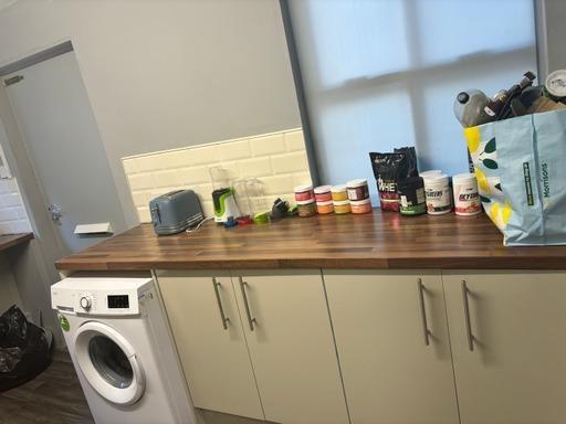 A compact kitchen area featuring a wooden count...