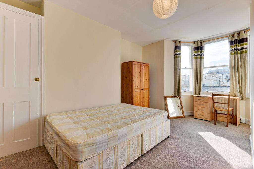 A spacious master bedroom featuring a large bed...