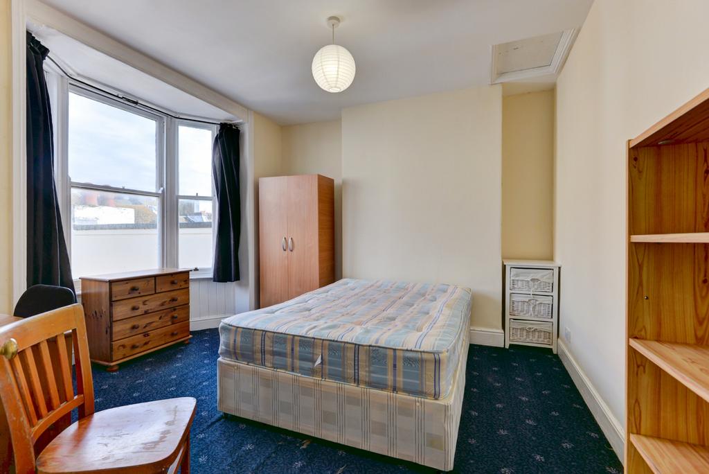 A spacious double bedroom with a comfortable be...