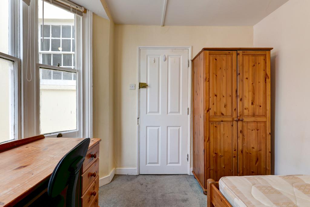 A bright and cozy bedroom featuring a wooden wa...