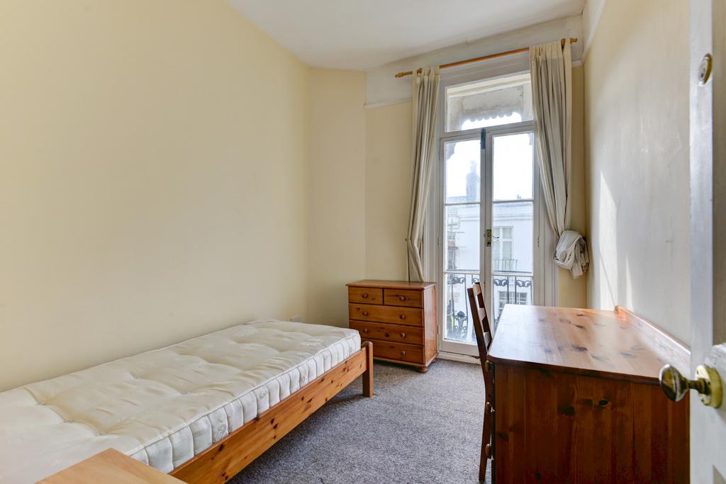 A bright and simple single bedroom featuring a ...
