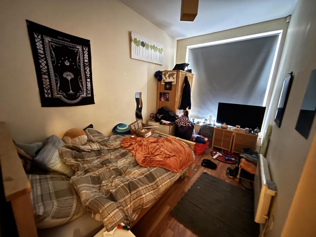 A cozy bedroom featuring a large bed, personal ...