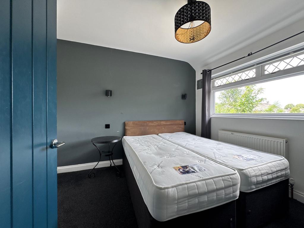 Bright, freshly styled bedroom with two comfort...