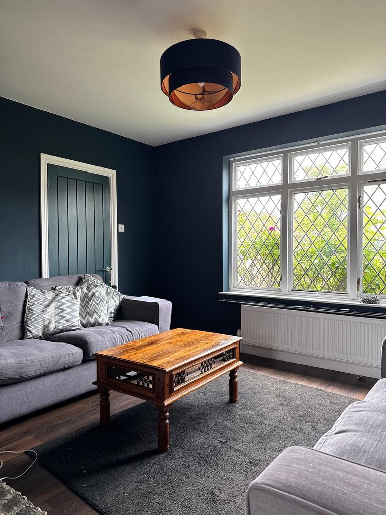 Bright, stylish living room with large leaded w...