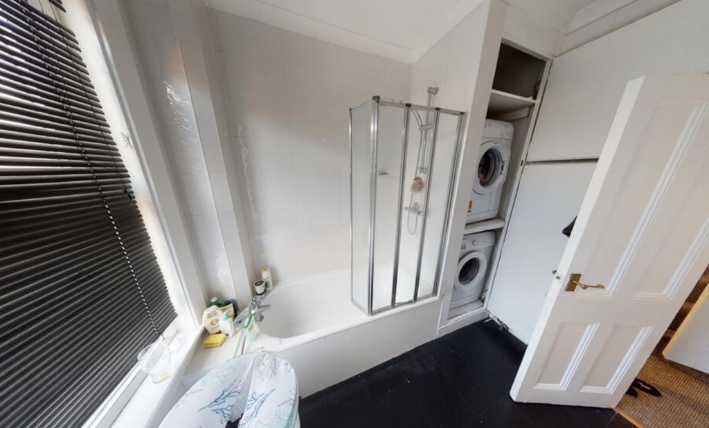 A bright and clean bathroom with a large shower...