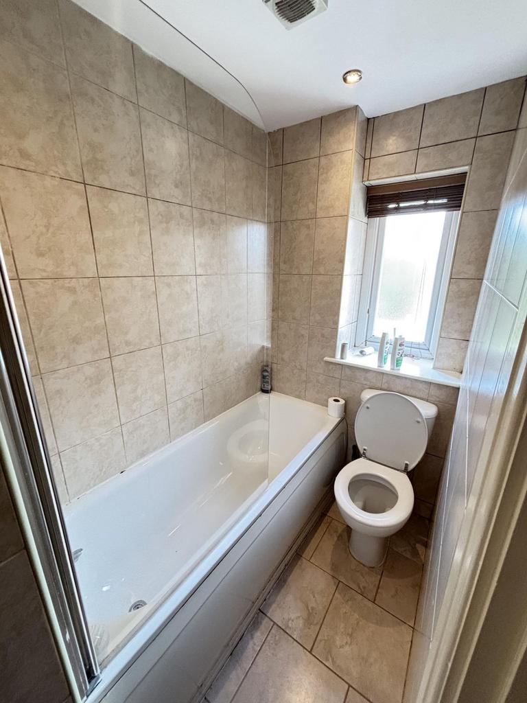 Bright and clean bathroom featuring a bathtub a...