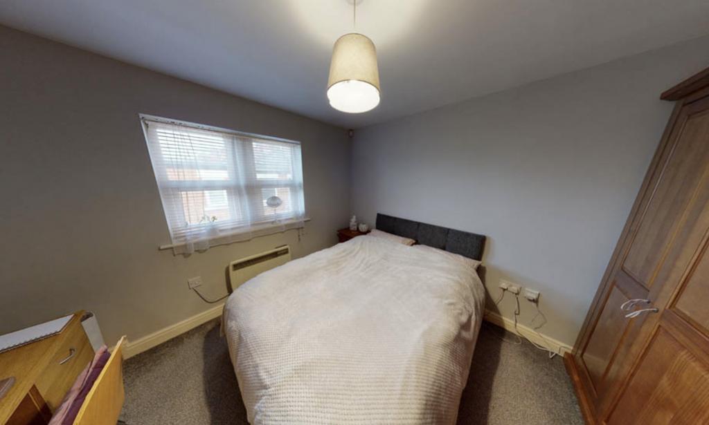 A cozy bedroom featuring a double bed with a ne...