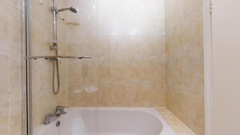 A clean and spacious bathroom with a large bath...