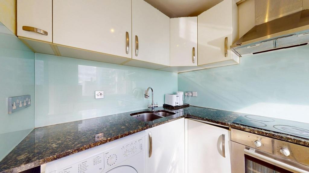 Modern kitchen with glossy white cabinets, a da...