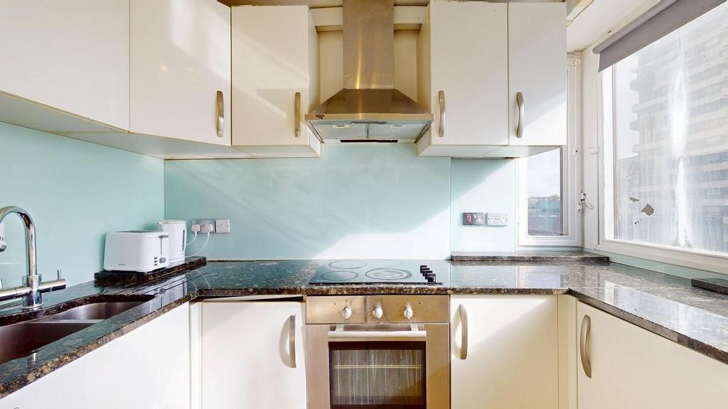 Bright and modern kitchen featuring a window wi...