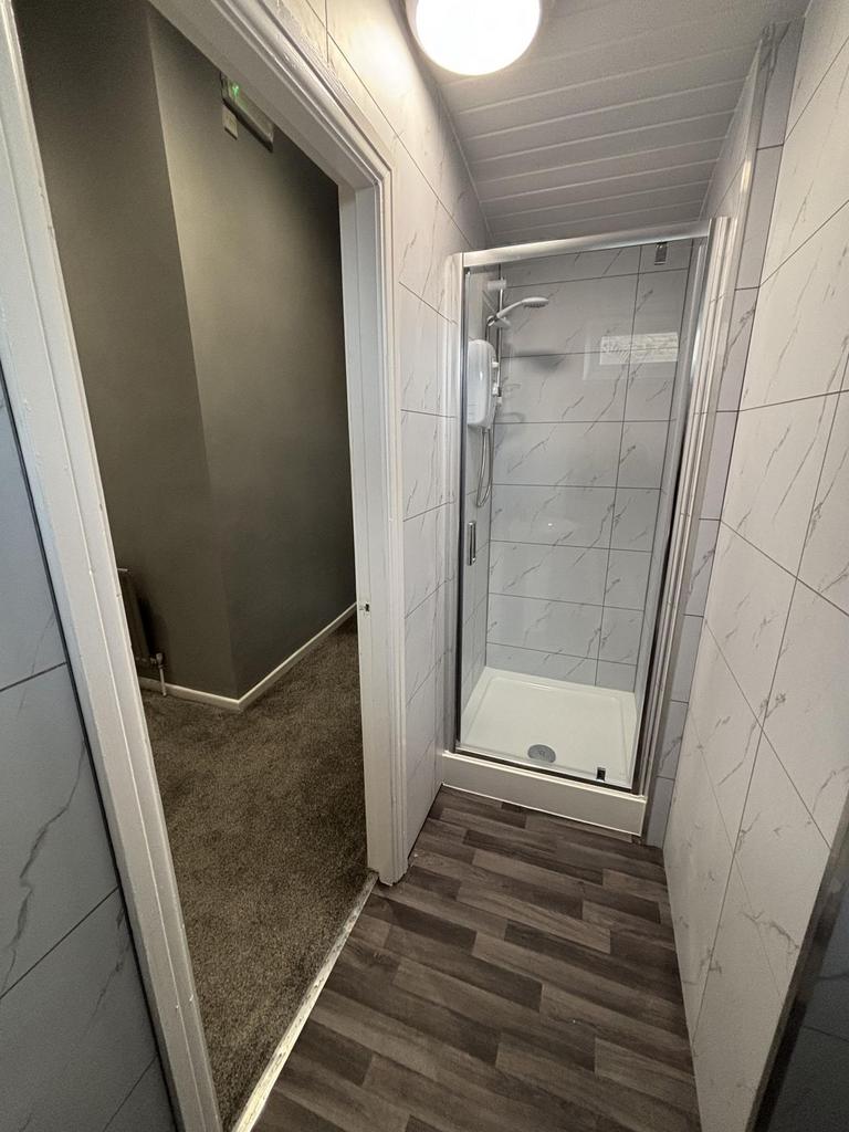 A modern bathroom featuring a glass-enclosed sh...