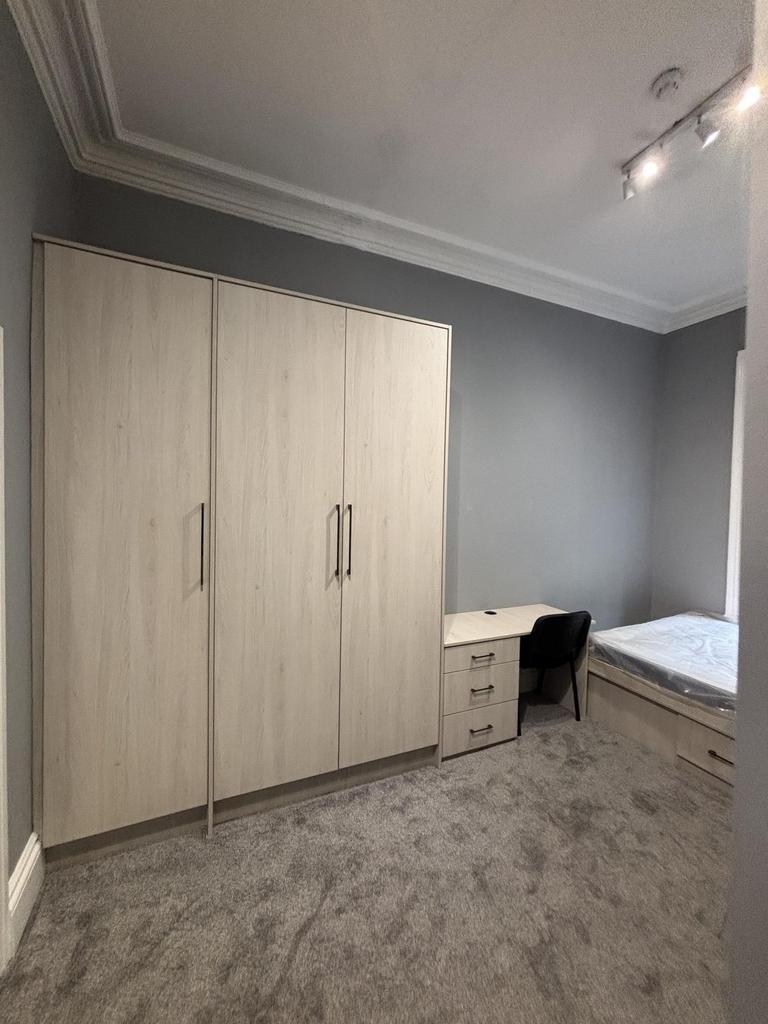 A bright and tidy bedroom featuring a large war...