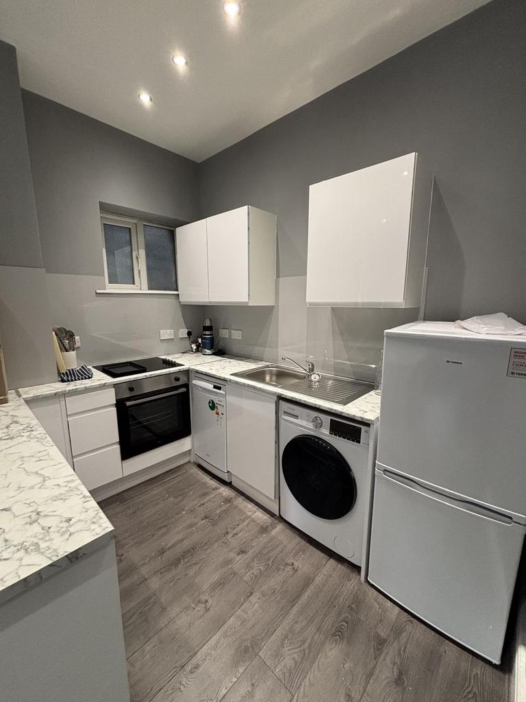 Bright and modern kitchen with ample white cabi...