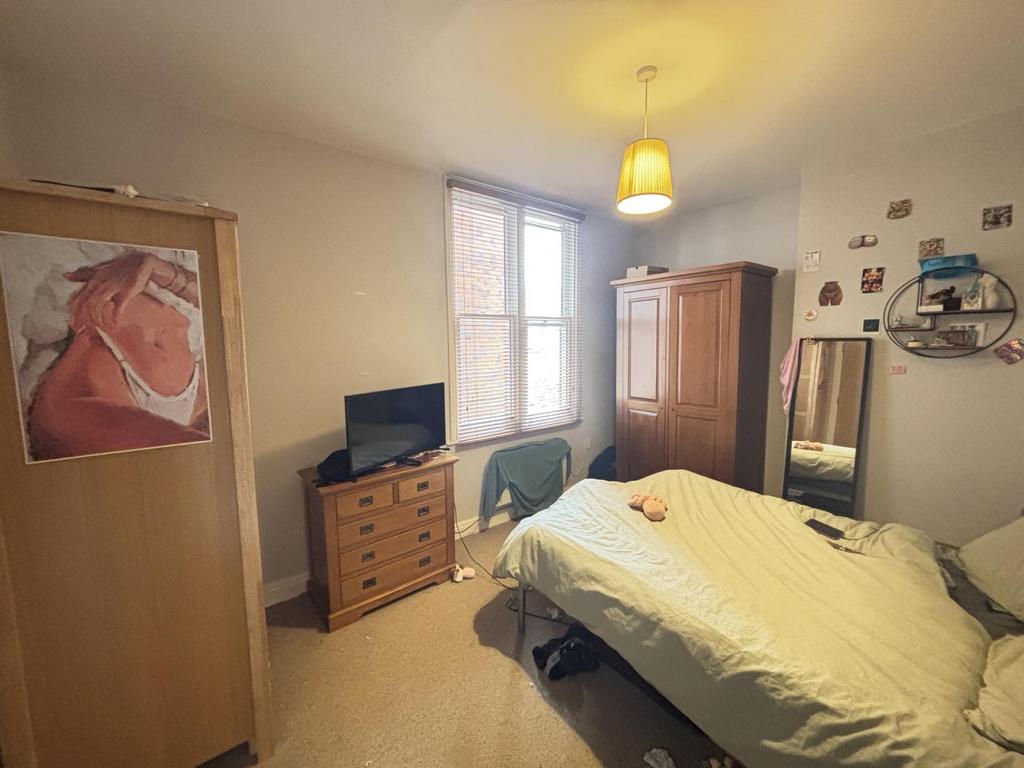 A spacious and well-lit bedroom featuring a lar...