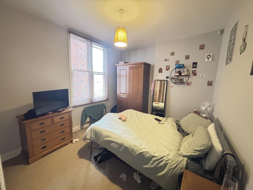 A spacious and bright master bedroom featuring ...