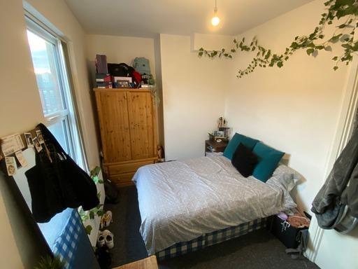 A cozy bedroom featuring a bed with pillows, a ...