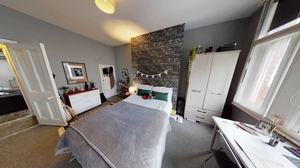 A bright and welcoming bedroom featuring a comf...