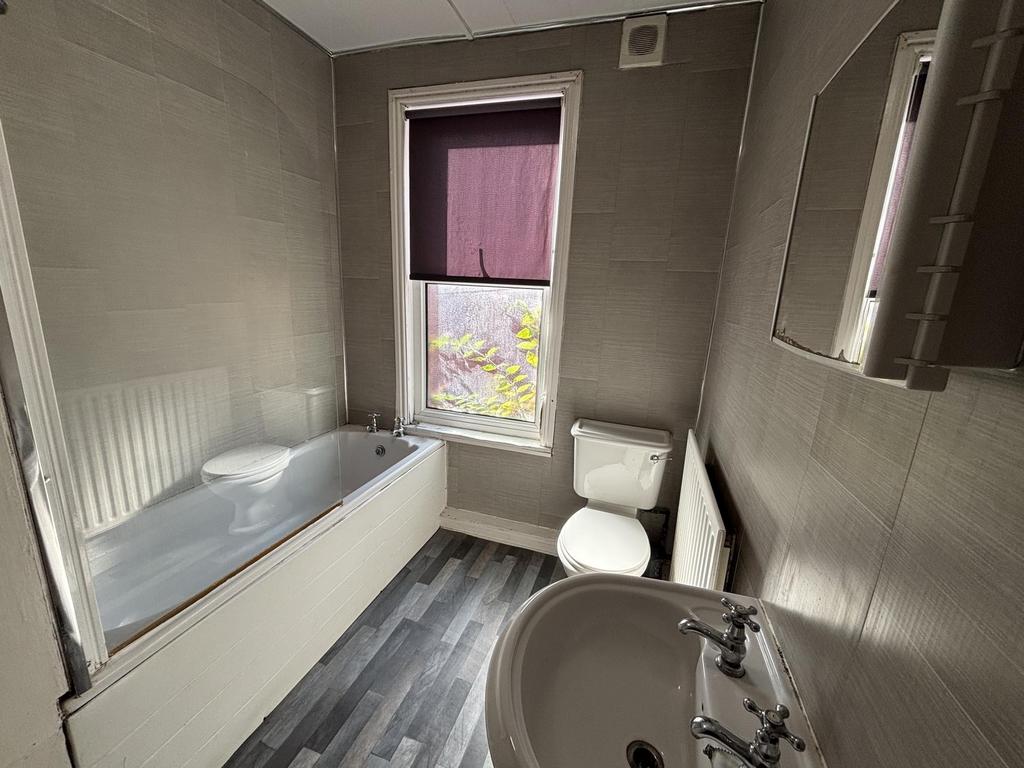 A well-maintained bathroom featuring a bathtub,...