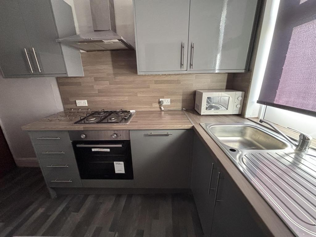 A modern kitchen with grey cabinets and a woode...