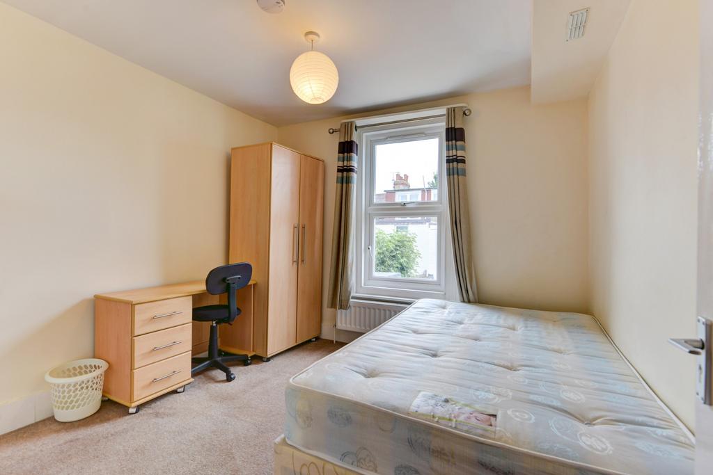 A bright, tidy bedroom featuring a comfortable ...
