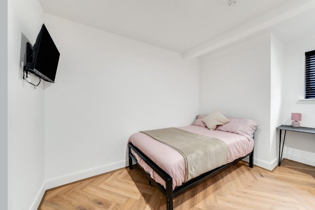 A bright and clean bedroom featuring a comforta...