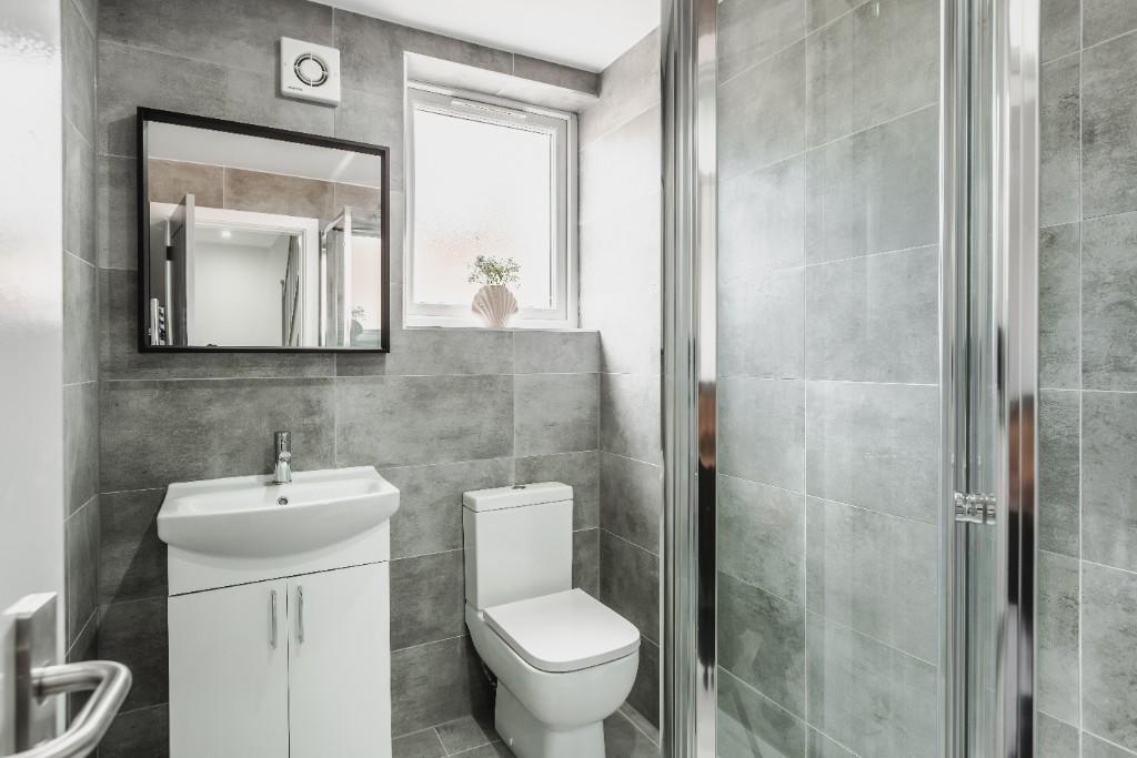 A modern, clean bathroom with a compact shower ...