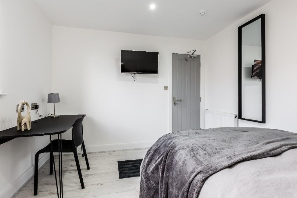A modern and tidy bedroom featuring a comfortab...