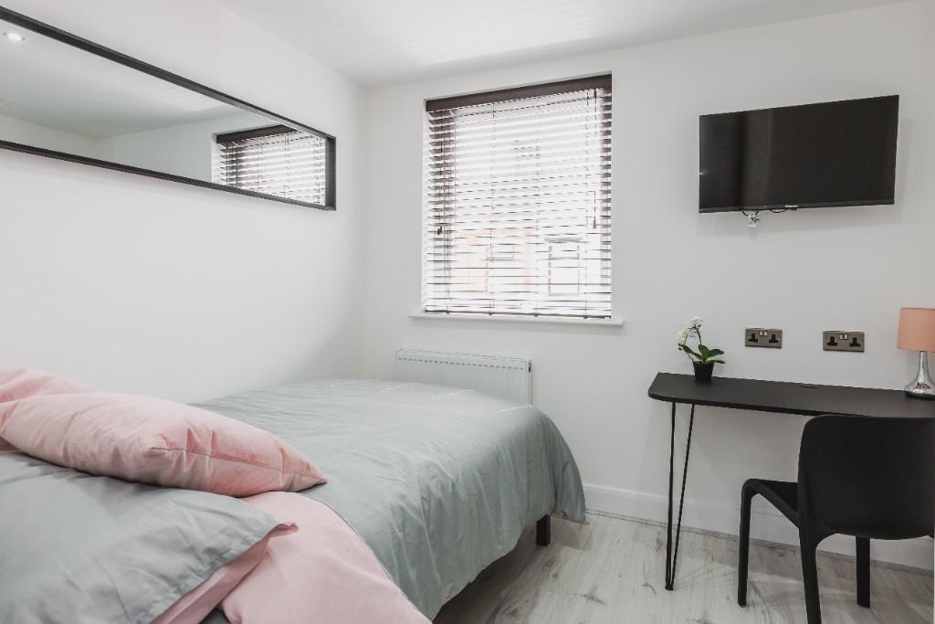 A clean and bright single bedroom featuring a n...
