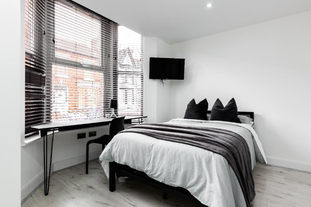 Bright and contemporary master bedroom featurin...