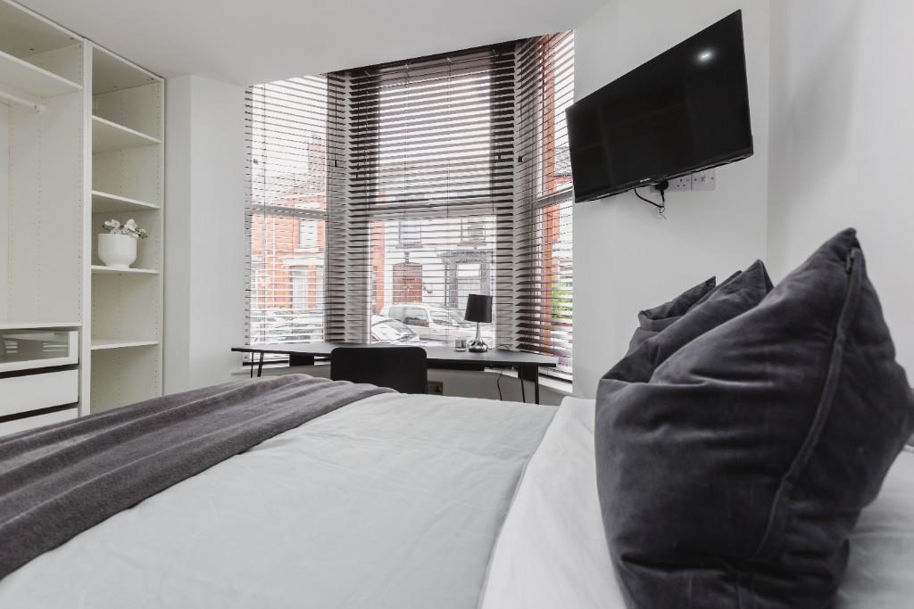 A spacious and modern master bedroom featuring ...