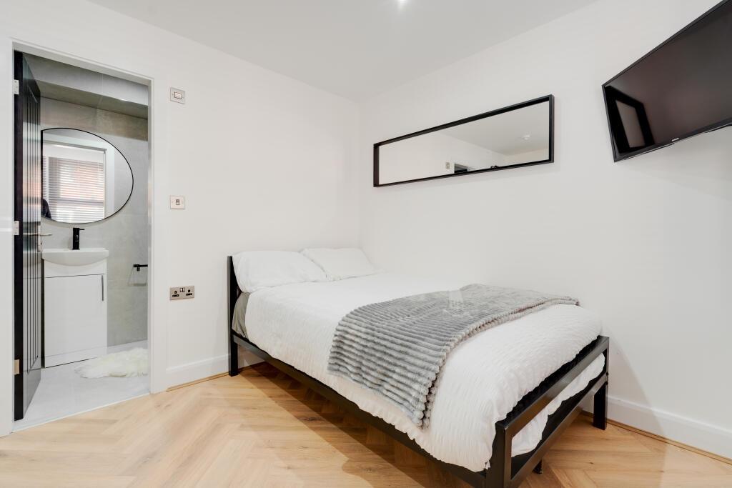 A bright and tidy bedroom featuring a comfortab...