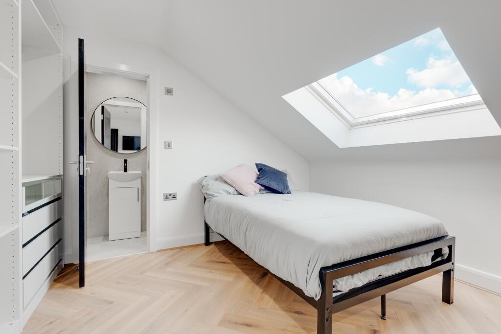 A bright, modern master bedroom with a comforta...