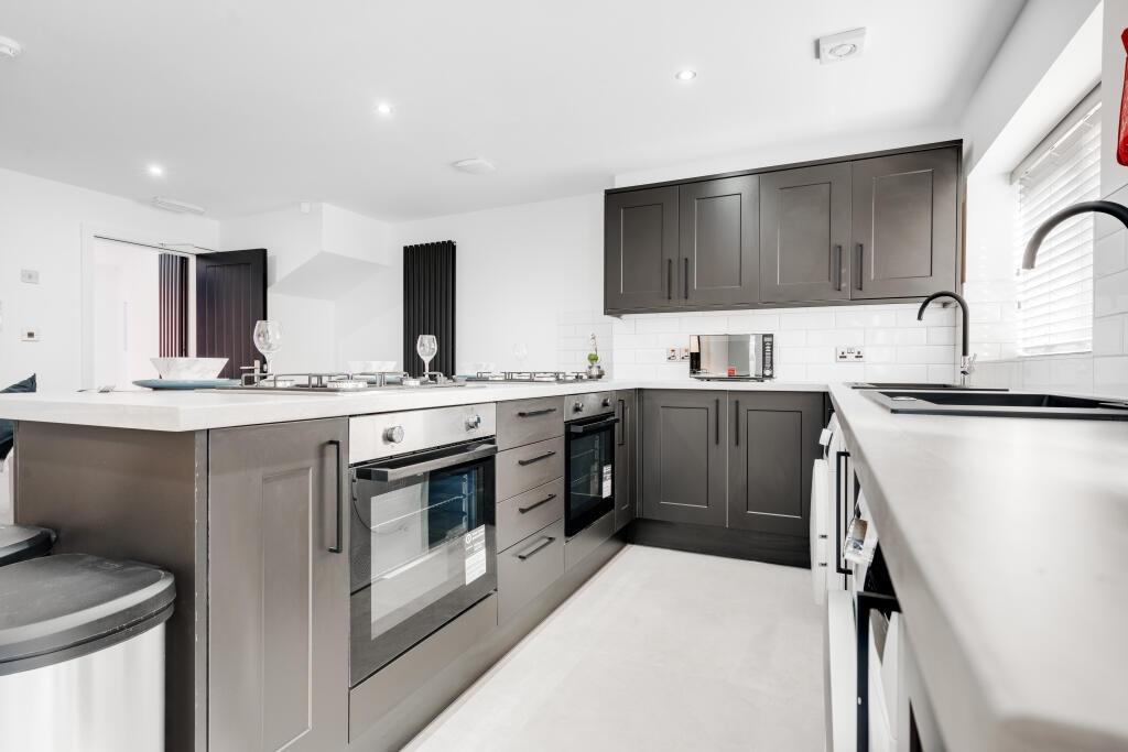 A bright and modern kitchen with sleek cabinetr...