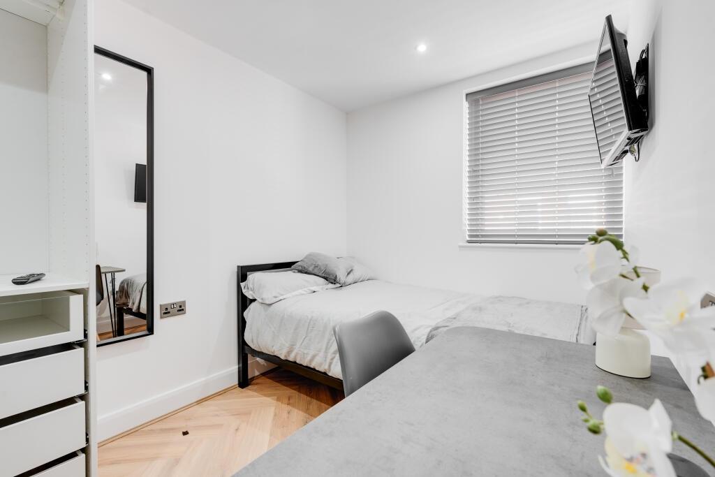 A bright and modern bedroom featuring a comfort...