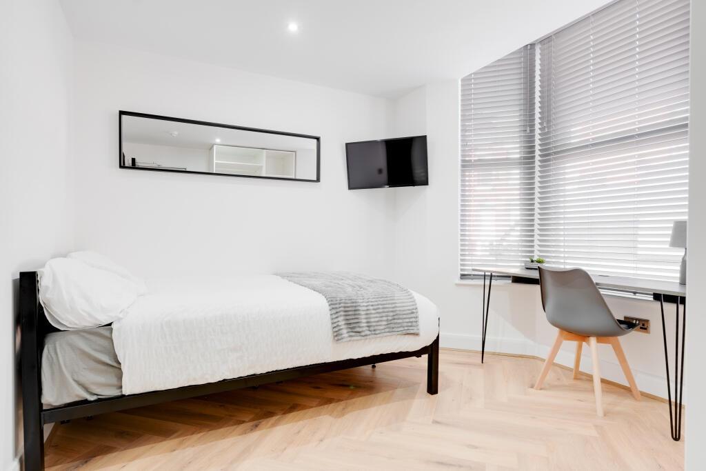 A modern, well-lit bedroom featuring a cozy dou...