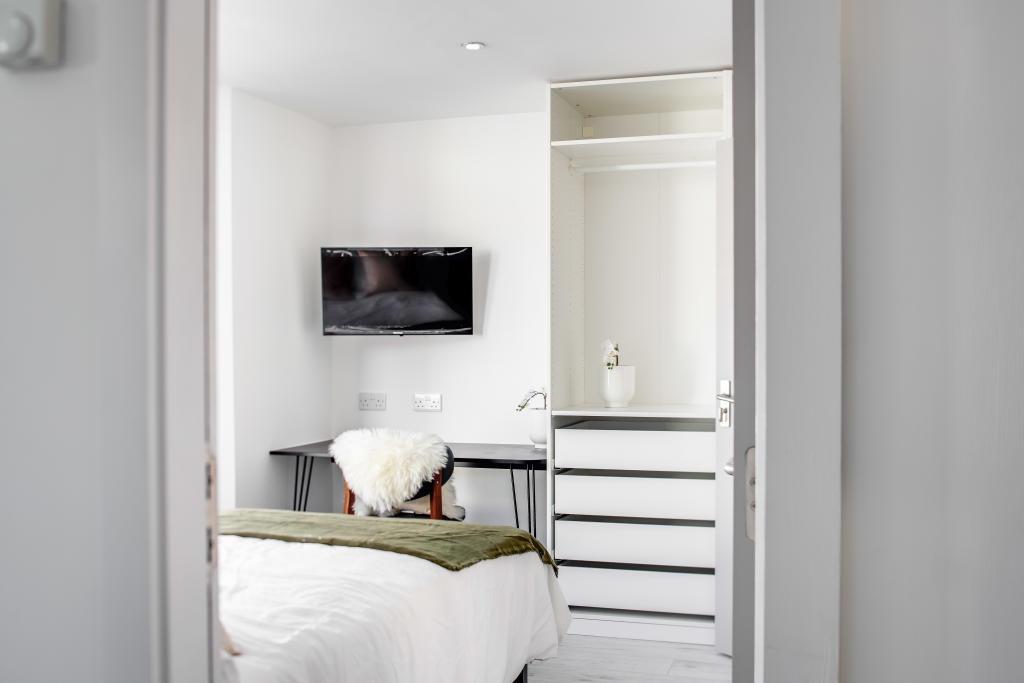 A bright and inviting bedroom featuring a neatl...