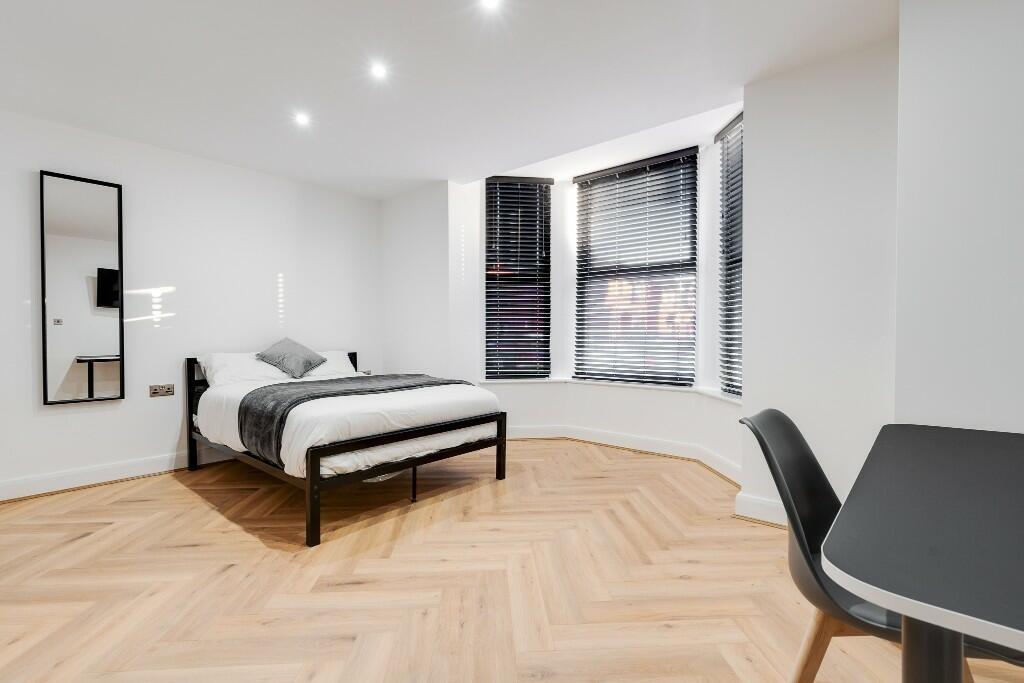 A bright, spacious living room with large windo...