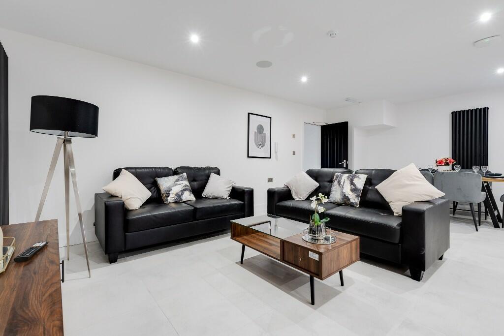 A spacious and modern living room featuring two...