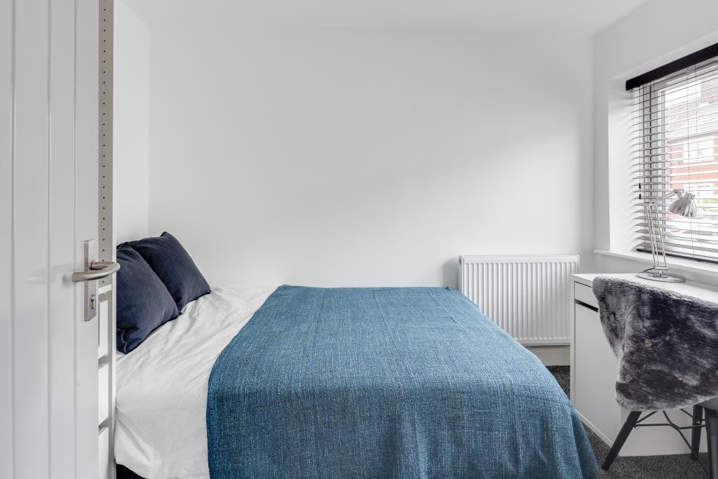 A bright and tidy single bedroom featuring a co...