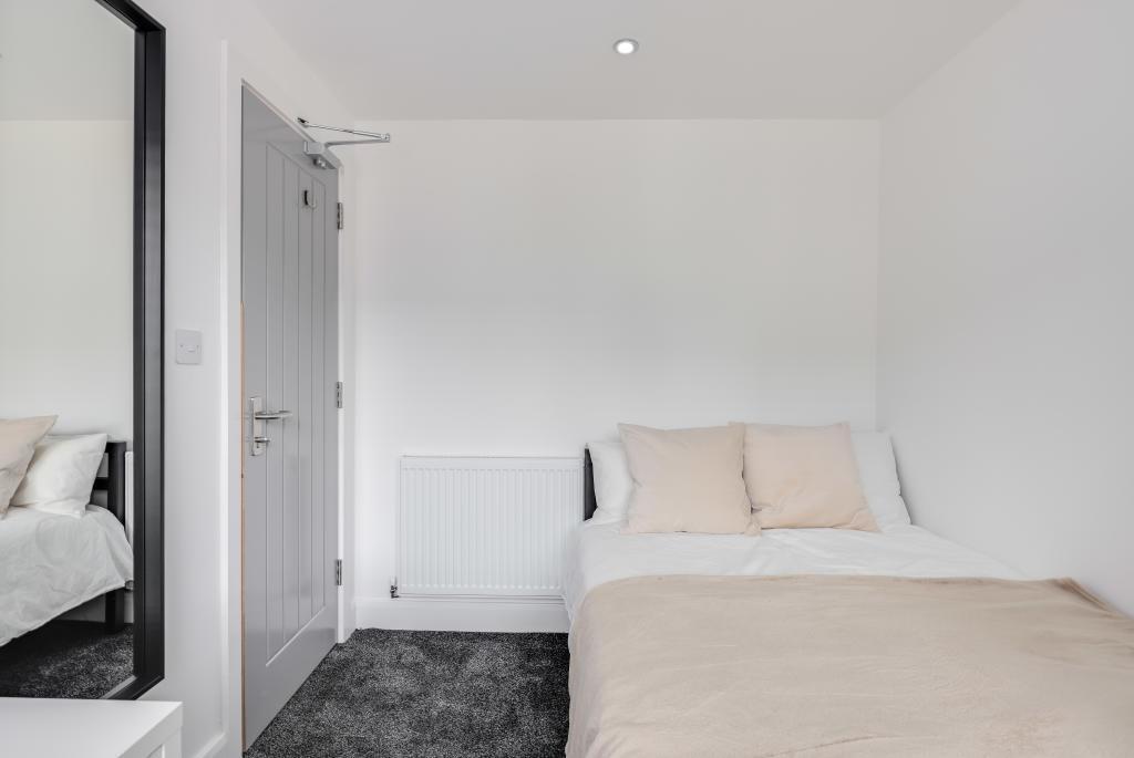 A bright and tidy bedroom featuring a double be...