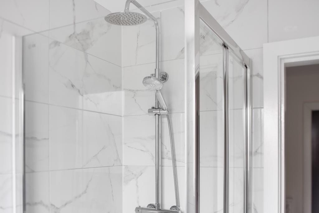 A modern bathroom suite featuring a spacious sh...